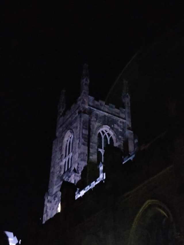 Holy Trinity tower illuminated at night.