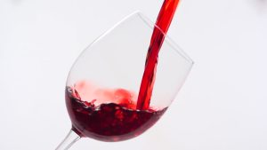 Red wine being poured into a glass.