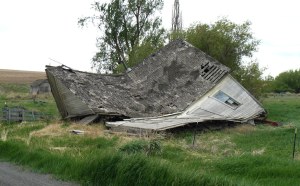 A collapsed house beside a road on moorland.