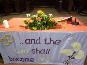 Flowers on a church altar. The altar front reads 