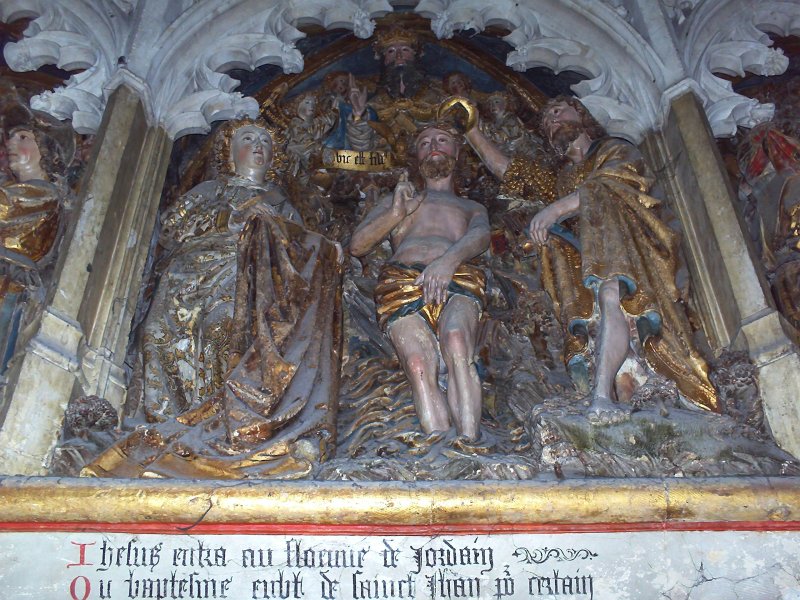 A church statue showing John the Baptist pouring water over a man in a loin clorh.