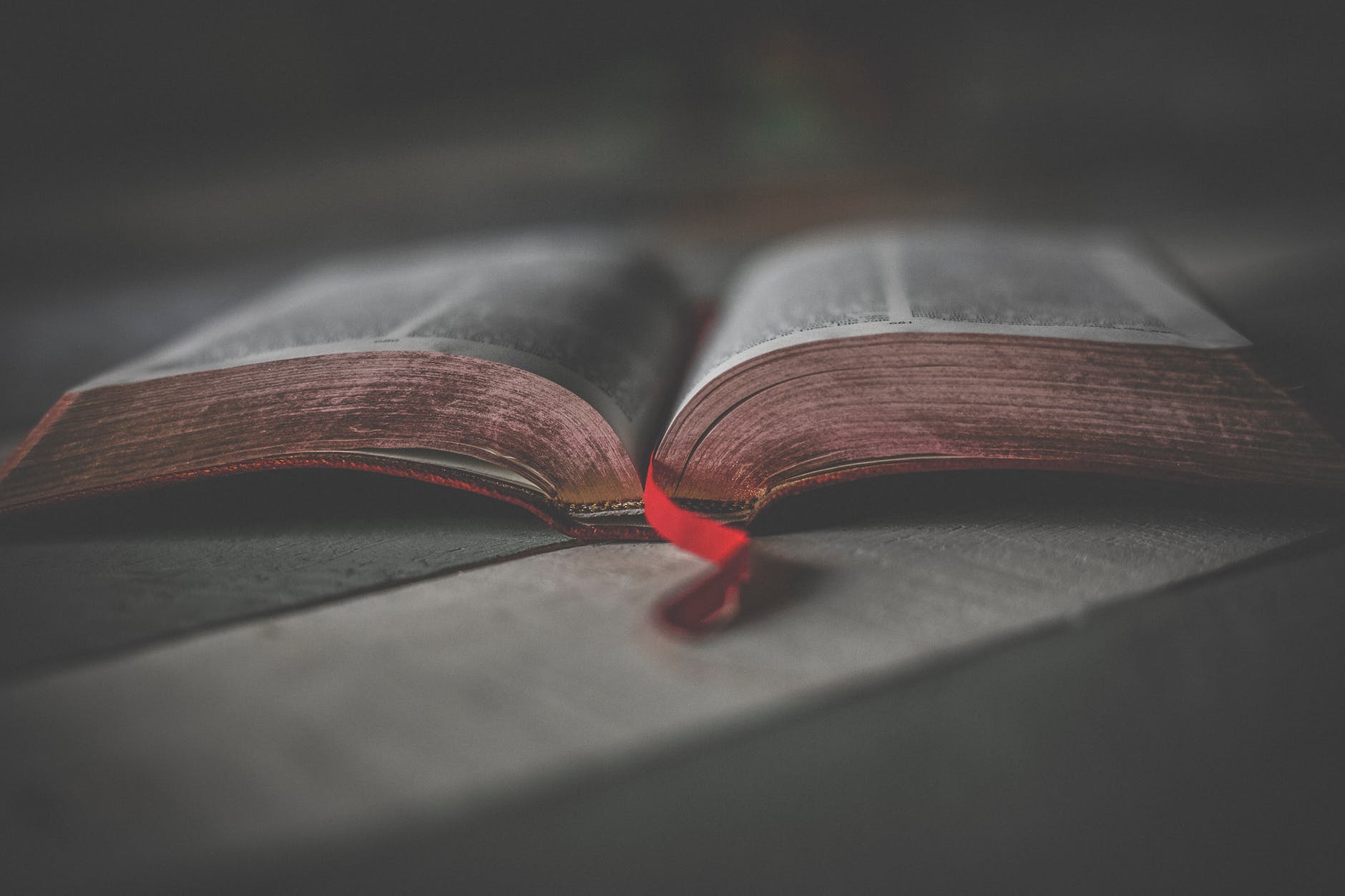 An open Bible with a red bookmark.