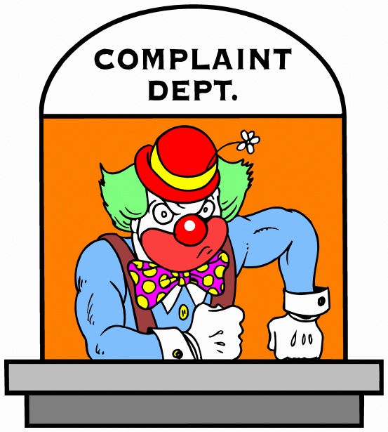 Cartoon: A clown in full make up is manning a window marked "Complaints Dept."