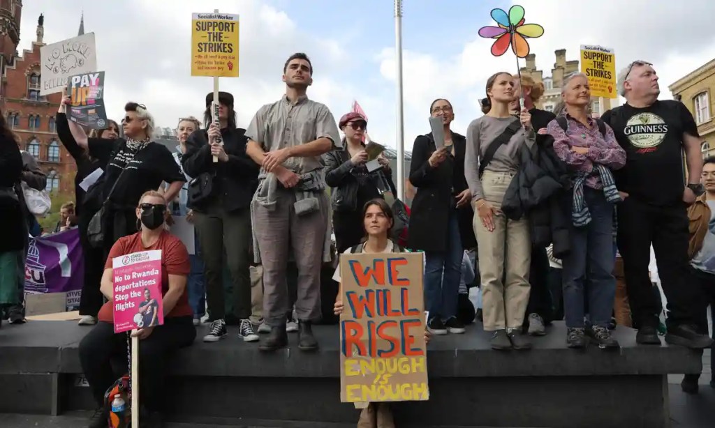 Protesters holding banners with captions including, "We will rise enough is enough," "Support the strikes." and "No to Rwanda deportations,Stop the Flights."