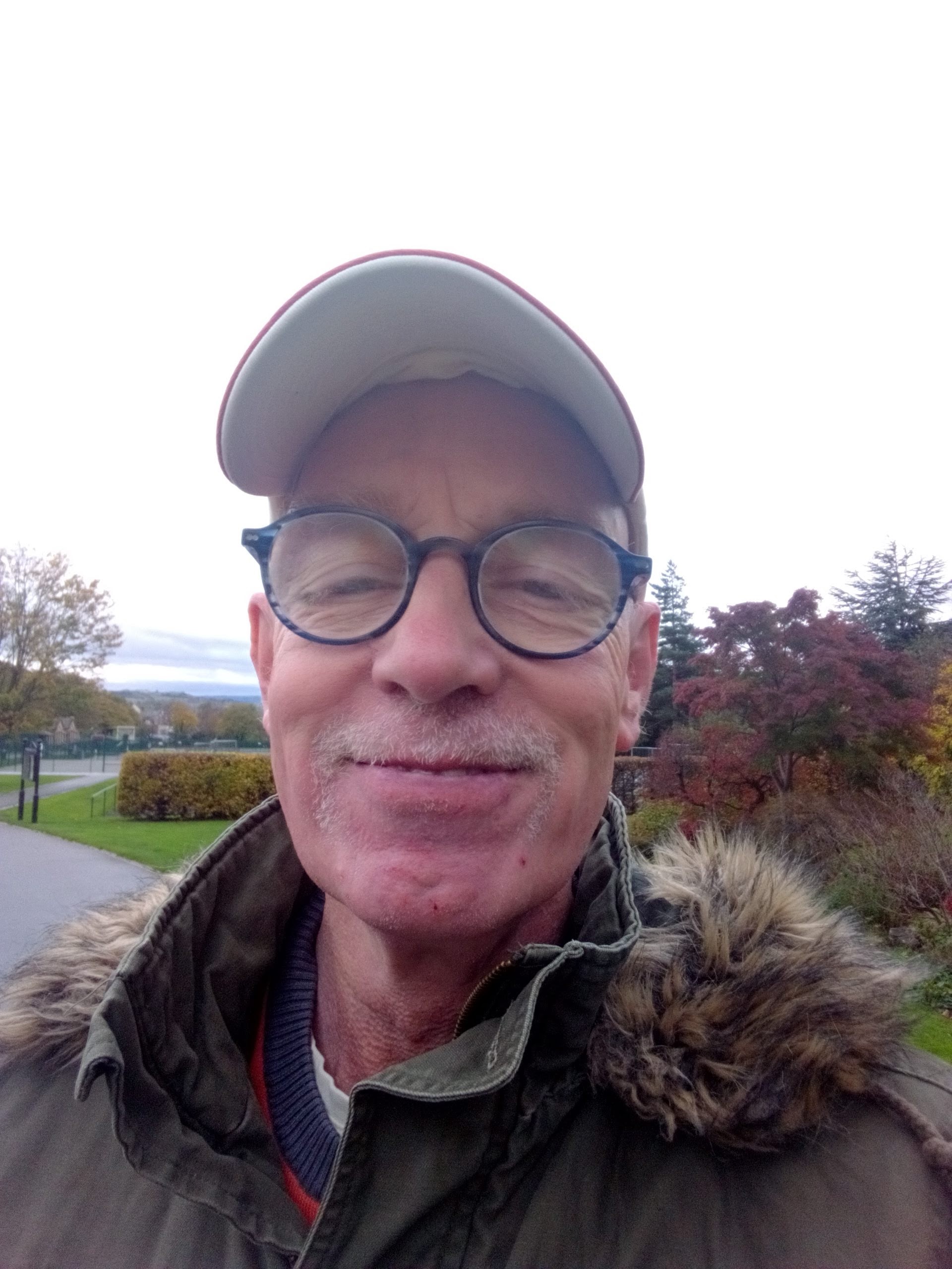 A selfie of me, standing in Greenhead Park which is resplendanr in Autum colours.