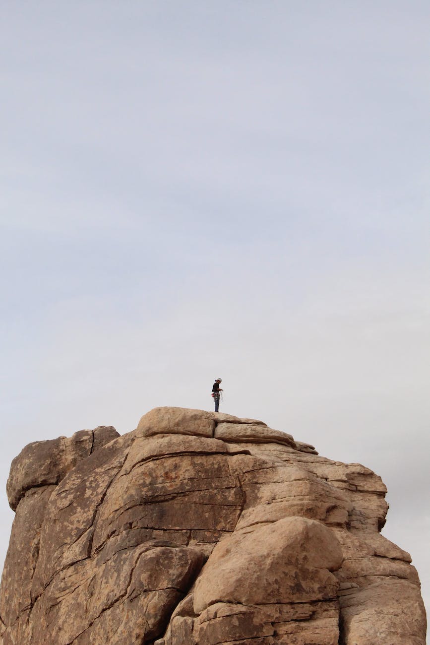 A man standing on a largeoutcrop of rock.