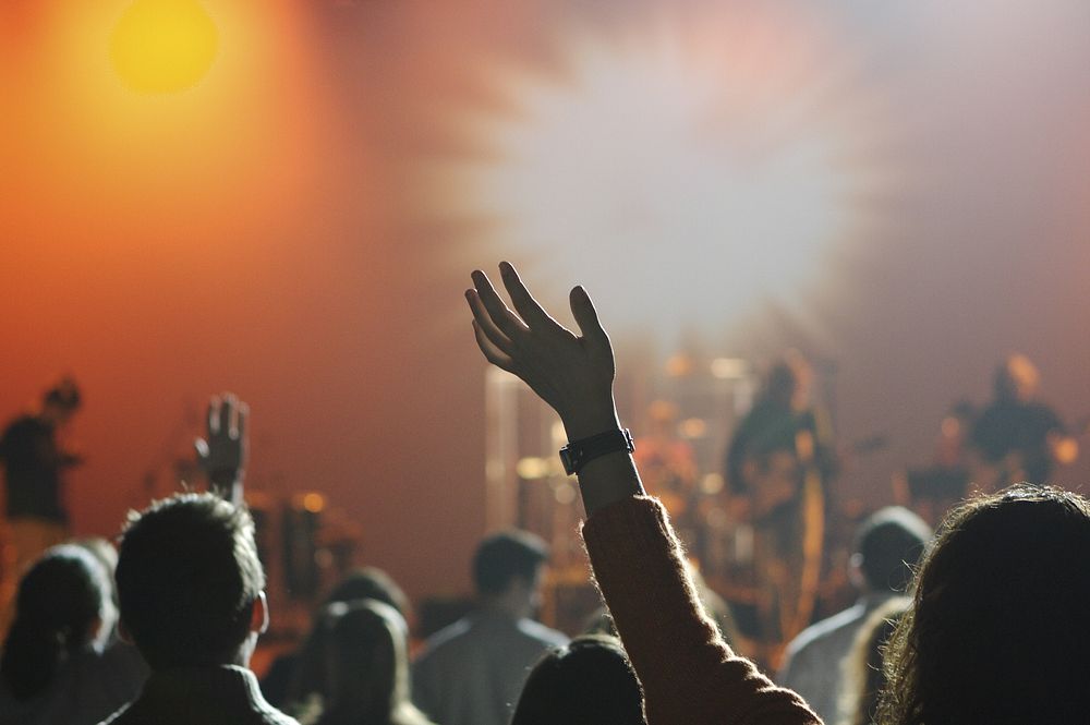 A blurred image of a worship band with the congregation, shot from behind, in focus.